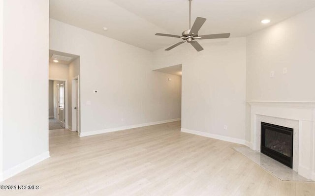 unfurnished living room featuring ceiling fan, a fireplace, and light hardwood / wood-style floors