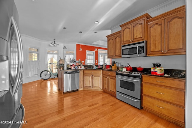 kitchen with pendant lighting, light wood-type flooring, ornamental molding, kitchen peninsula, and stainless steel appliances