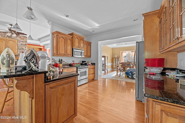 kitchen featuring stainless steel appliances, kitchen peninsula, crown molding, decorative light fixtures, and light wood-type flooring