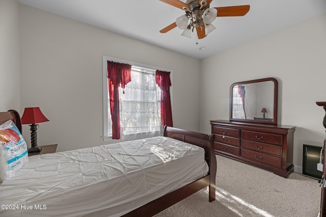 carpeted bedroom with ceiling fan and multiple windows