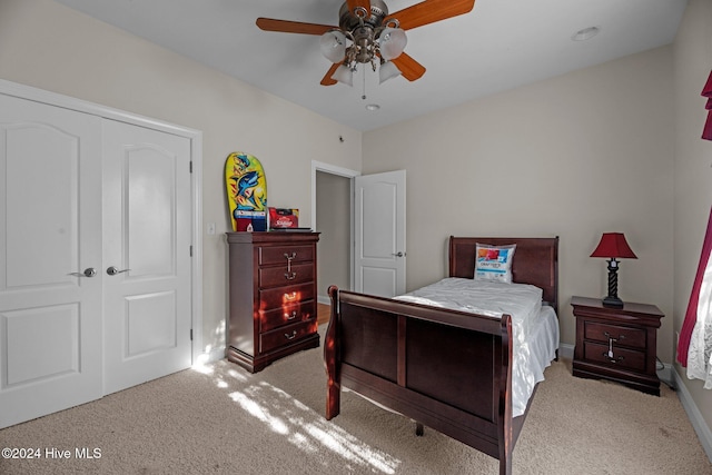 bedroom featuring ceiling fan, light colored carpet, and a closet