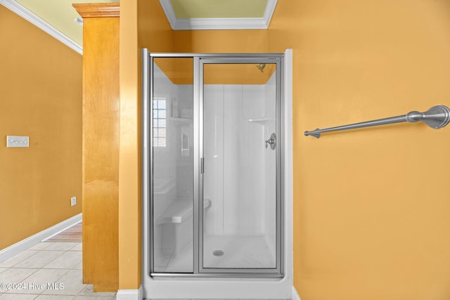 bathroom with tile patterned flooring, a shower with shower door, and crown molding