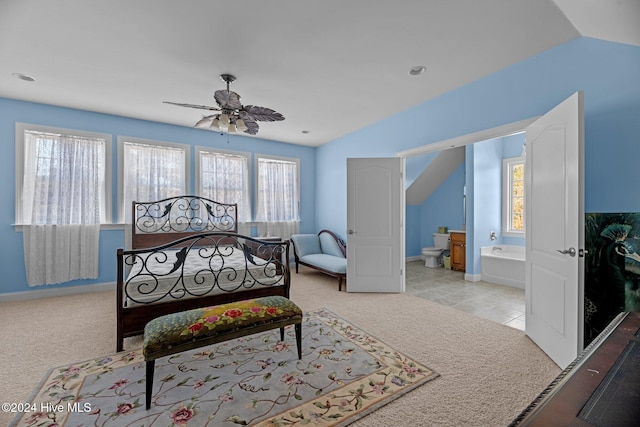 carpeted bedroom featuring multiple windows, ensuite bathroom, ceiling fan, and lofted ceiling