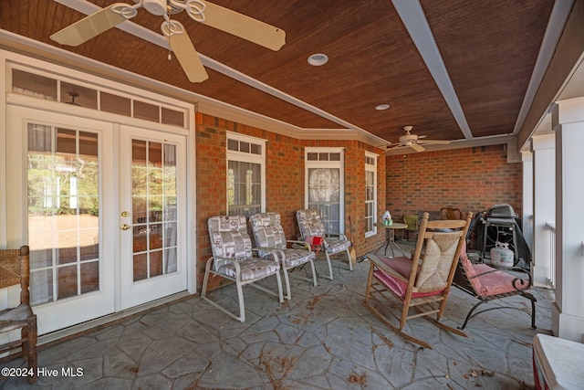 unfurnished sunroom with ceiling fan, wood ceiling, and french doors