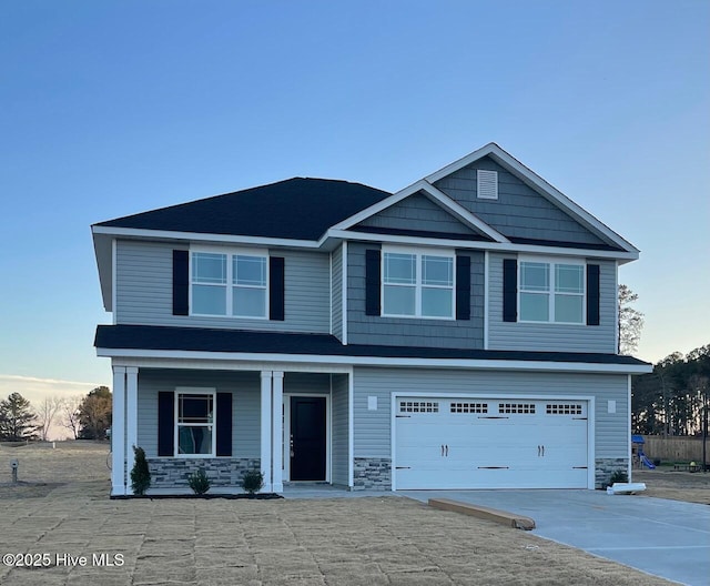 craftsman-style house with driveway, stone siding, a garage, and covered porch