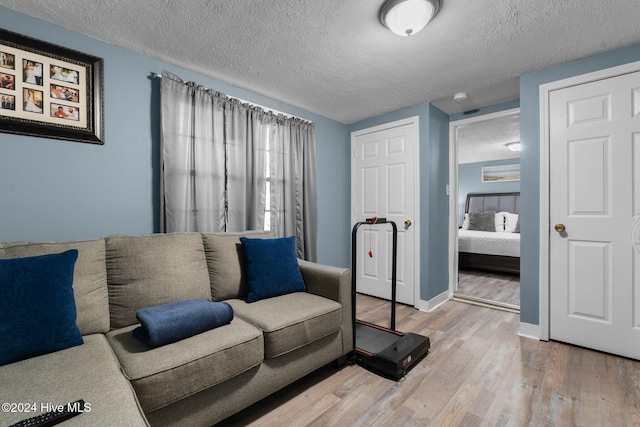 living room with wood-type flooring and a textured ceiling