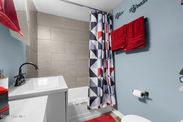 full bathroom with vanity, shower / bath combination with curtain, a textured ceiling, and toilet