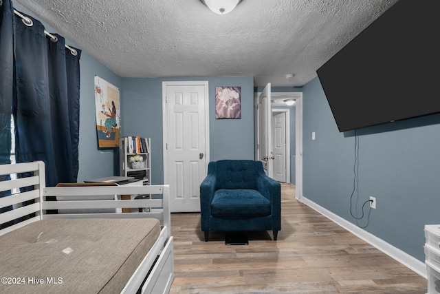 bedroom featuring a textured ceiling and light wood-type flooring