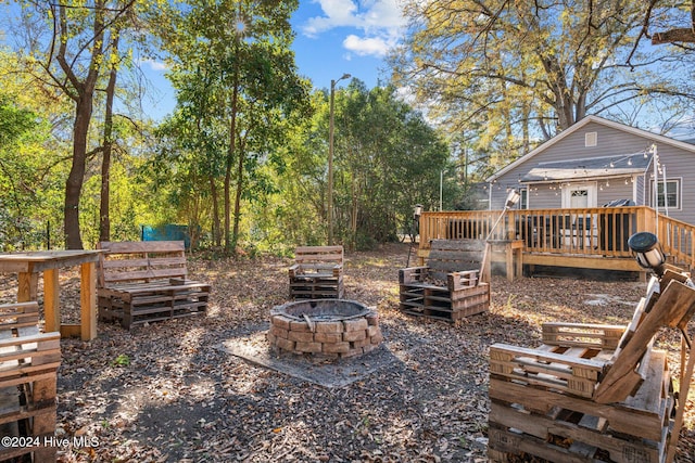 view of yard with a deck and an outdoor fire pit