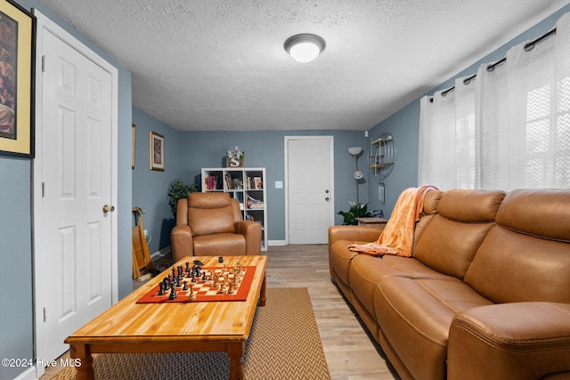 living room with a textured ceiling and light wood-type flooring