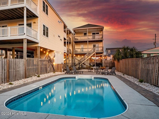 pool at dusk with a patio