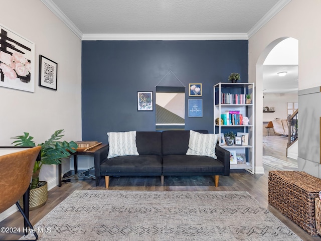 living room featuring hardwood / wood-style flooring, a textured ceiling, and crown molding