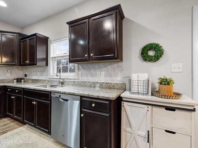 kitchen featuring decorative backsplash, light wood-type flooring, dishwasher, dark brown cabinetry, and sink