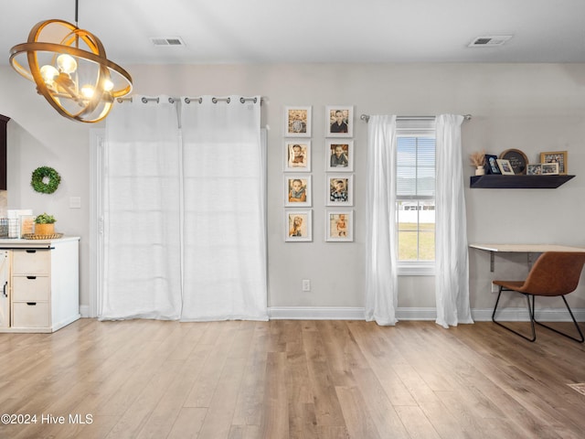 dining space featuring light wood-type flooring and an inviting chandelier