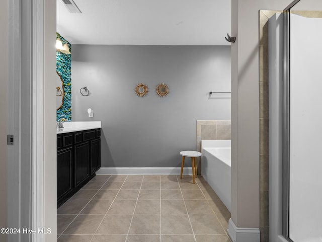 bathroom with a bathtub, vanity, and tile patterned flooring