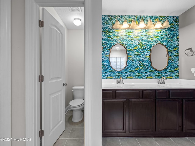 bathroom featuring toilet, vanity, tile patterned flooring, and a textured ceiling