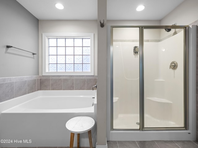 bathroom featuring tile patterned flooring and shower with separate bathtub