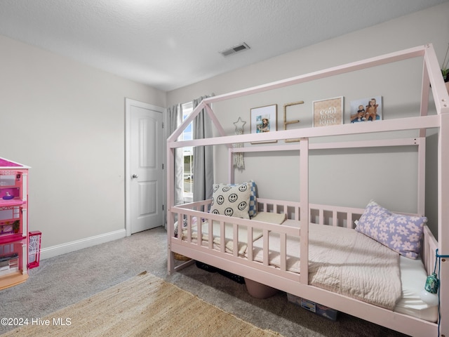 bedroom featuring carpet floors and a textured ceiling