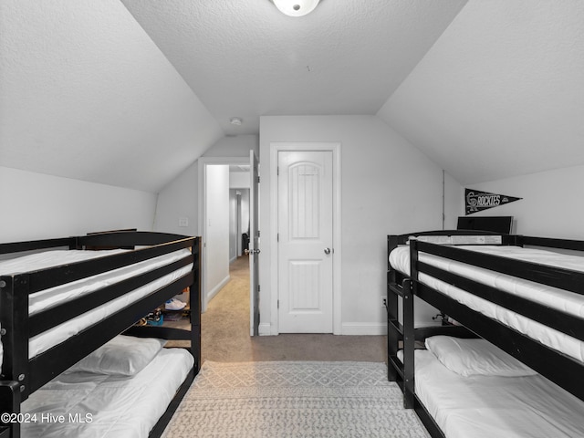 carpeted bedroom with lofted ceiling and a textured ceiling