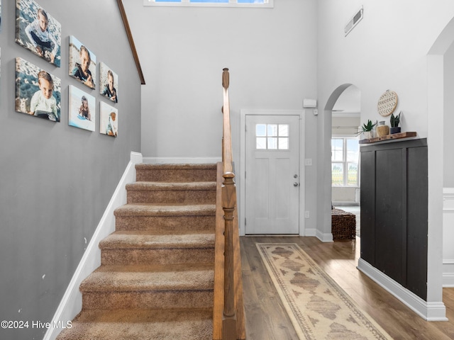 entrance foyer featuring wood-type flooring and a towering ceiling