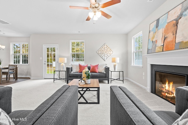 carpeted living room with ceiling fan and a healthy amount of sunlight