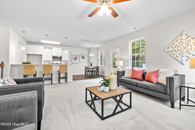 carpeted living room with ceiling fan