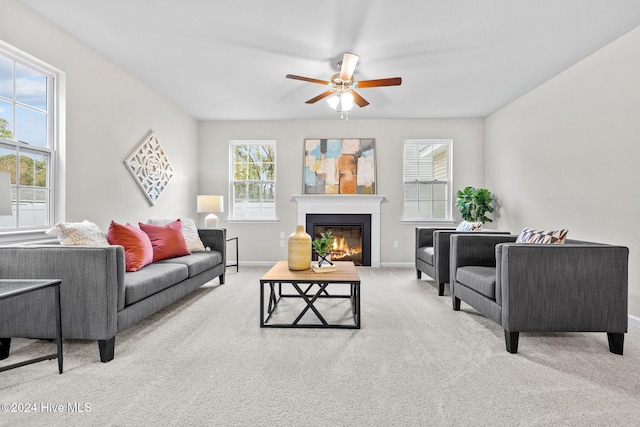 living room featuring light carpet, ceiling fan, and a healthy amount of sunlight