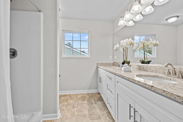 bathroom featuring a shower and vanity