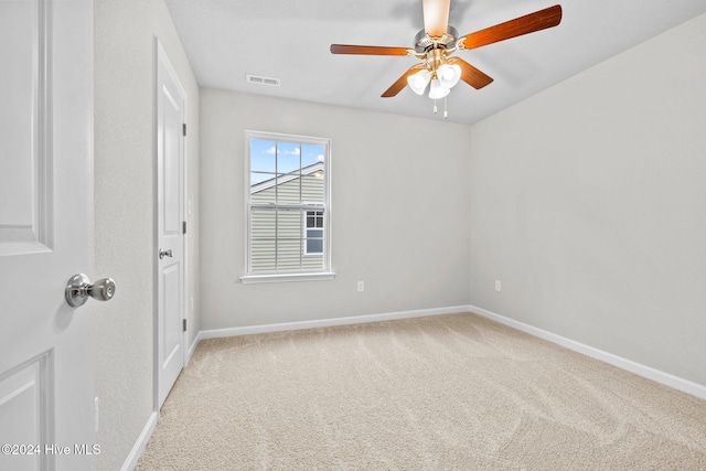 carpeted spare room featuring ceiling fan