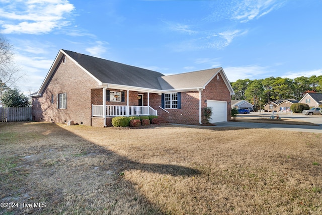 view of front of house featuring covered porch, a garage, and a front yard