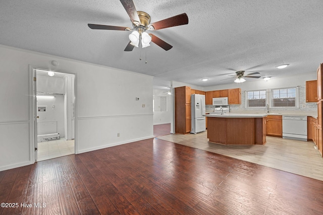 kitchen with sink, white appliances, and light hardwood / wood-style flooring