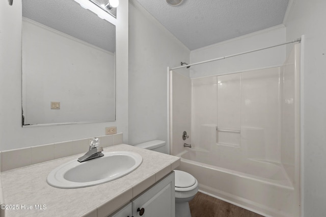 full bathroom featuring vanity, wood-type flooring, a textured ceiling, shower / bathtub combination, and toilet