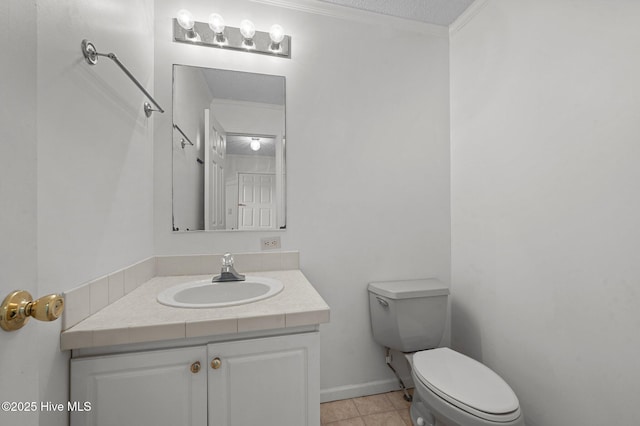 bathroom featuring vanity, ornamental molding, a textured ceiling, tile patterned floors, and toilet