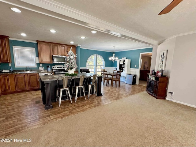 kitchen with a kitchen breakfast bar, a kitchen island, wood-type flooring, and appliances with stainless steel finishes