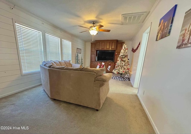 living room featuring light carpet, ceiling fan, and wood walls