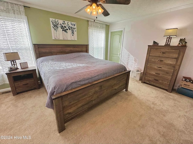 carpeted bedroom featuring ceiling fan and crown molding