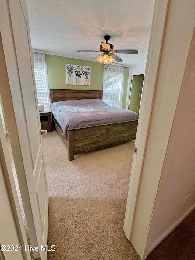 carpeted bedroom featuring a textured ceiling and ceiling fan