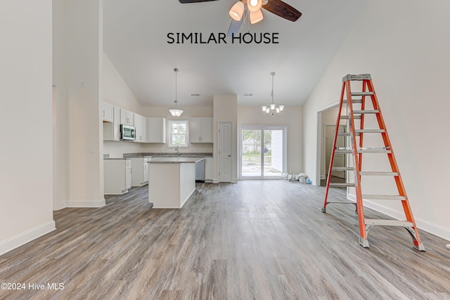 kitchen featuring white cabinetry, a center island, hanging light fixtures, light hardwood / wood-style flooring, and ceiling fan with notable chandelier