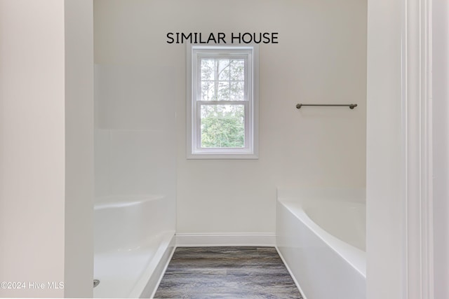 bathroom featuring hardwood / wood-style flooring and a bath