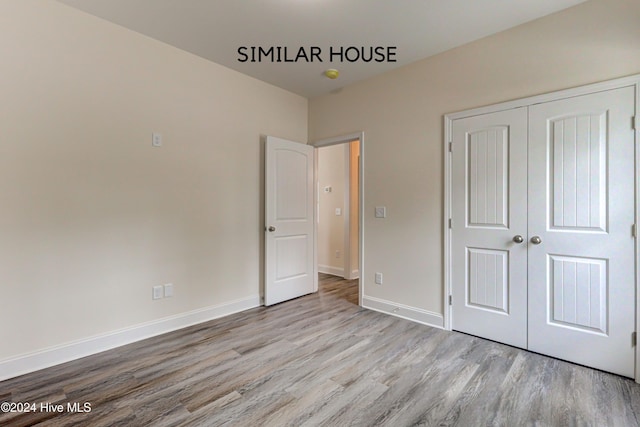 unfurnished bedroom featuring light hardwood / wood-style floors and a closet