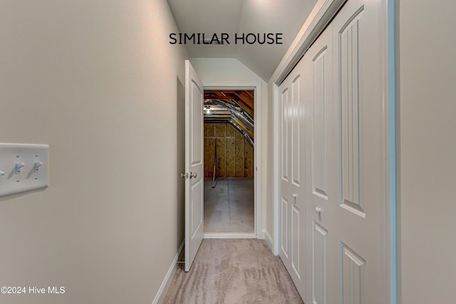 corridor featuring light carpet and vaulted ceiling