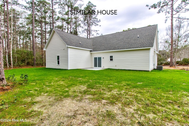 back of property with central AC unit and a yard