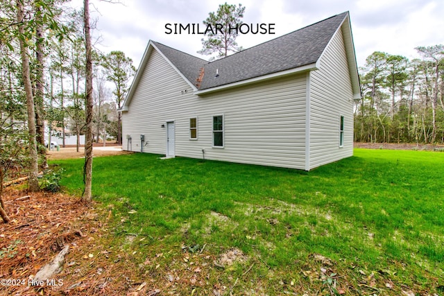 rear view of property featuring a lawn