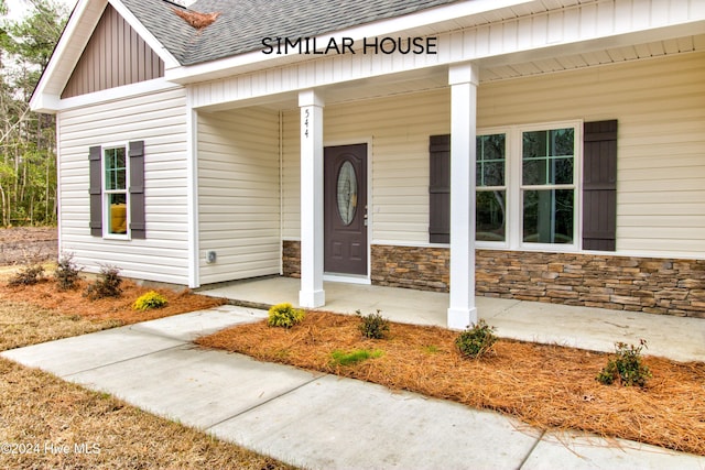 view of exterior entry featuring covered porch