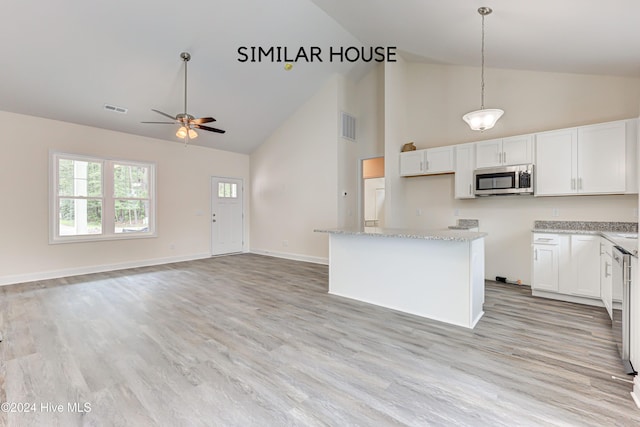 kitchen with white cabinets, light hardwood / wood-style flooring, ceiling fan, decorative light fixtures, and a kitchen island