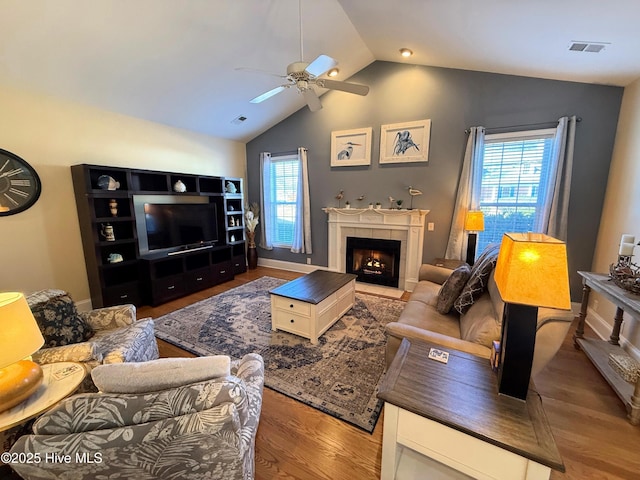 living room featuring ceiling fan, wood-type flooring, and vaulted ceiling