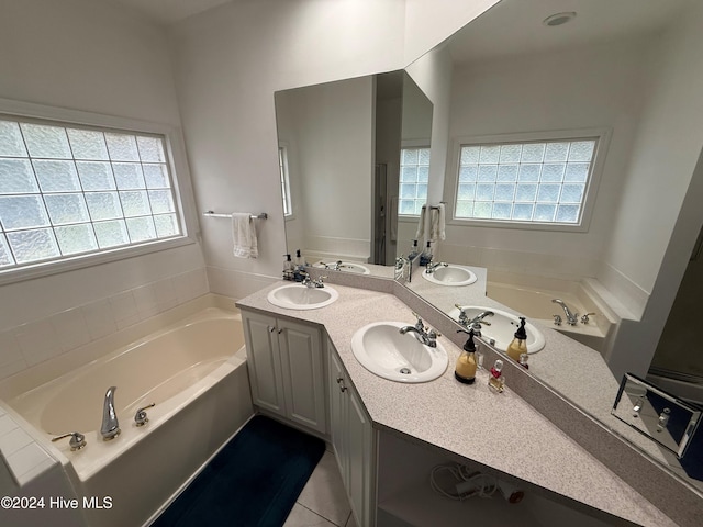 bathroom featuring a washtub, vanity, tile patterned floors, and plenty of natural light