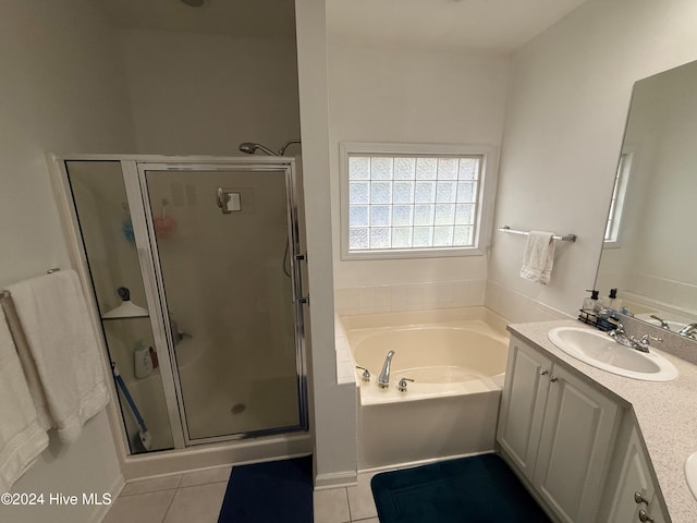 bathroom with tile patterned floors, vanity, and shower with separate bathtub