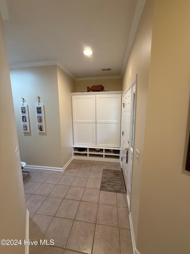 mudroom featuring ornamental molding and light tile patterned flooring