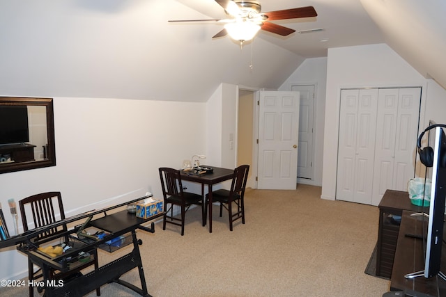 dining area with ceiling fan, light carpet, and vaulted ceiling